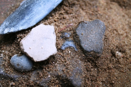 Fragmenty naczyń i krzemienny grot strzały złożone w jednym z odkrytych depozytów